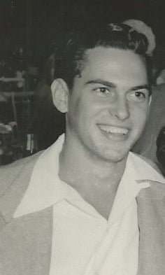 A black and white photo of a man smiling from the 1970s.